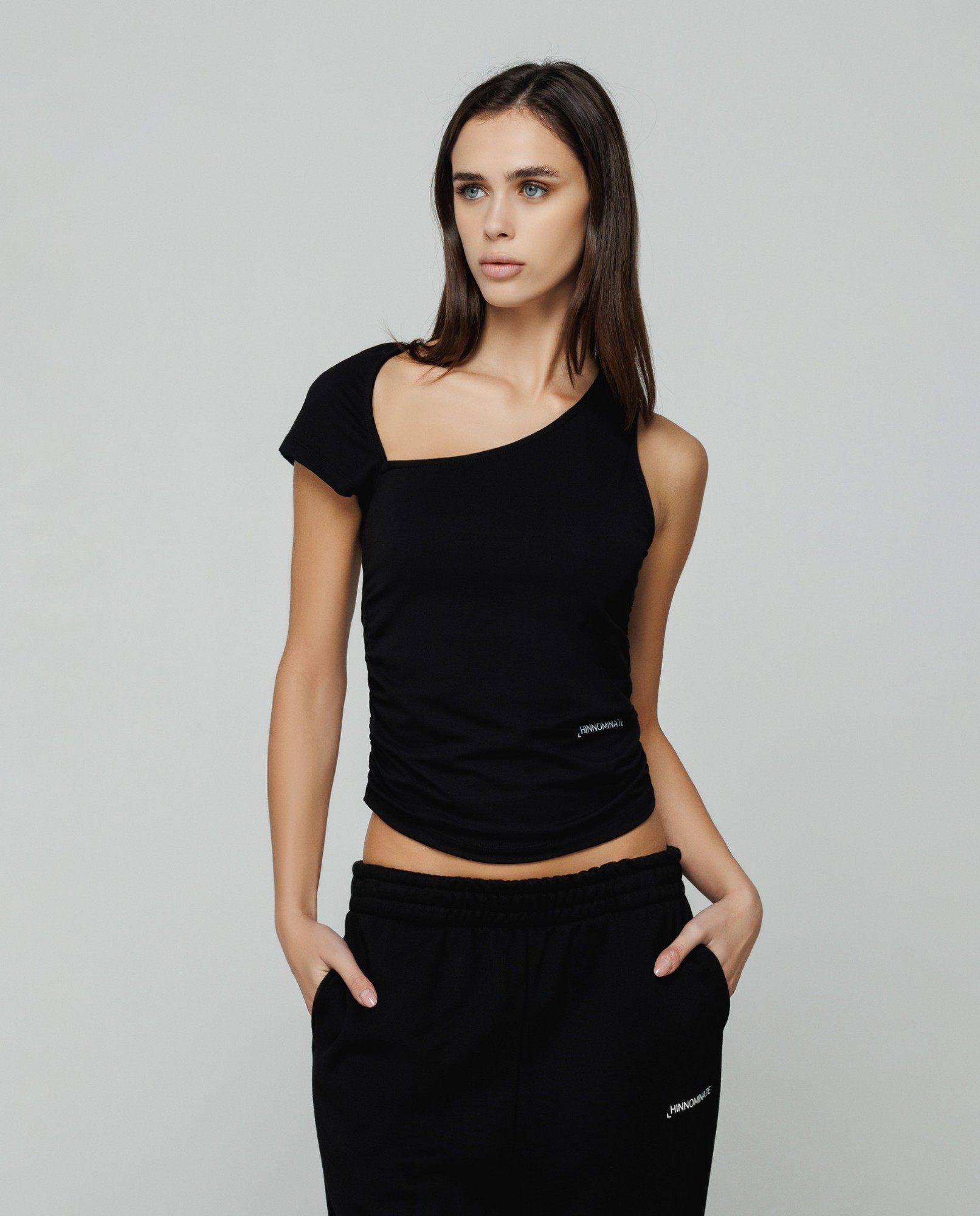 T-shirt asimmetrica in bielastico con drappeggio laterale • Nero